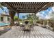 Covered outdoor seating area with elegant pergola, table, and views of the lush garden at 8229 N Ridgeview Dr, Paradise Valley, AZ 85253