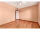 Peach bedroom with wood laminate flooring, a door to the hall, and a ceiling fan at 8238 E Jackrabbit Rd, Scottsdale, AZ 85250