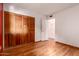 Bedroom featuring wood laminate flooring, closet with shutter doors, and door at 8238 E Jackrabbit Rd, Scottsdale, AZ 85250