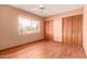Bedroom with a large window, wood laminate flooring, and closet with shutter doors at 8238 E Jackrabbit Rd, Scottsdale, AZ 85250