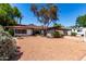 Inviting single-story home with a xeriscaped front yard, mature trees, and an RV parked on the driveway at 8238 E Jackrabbit Rd, Scottsdale, AZ 85250