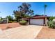 Single-story home with a two-car garage, xeriscaped front yard, mature trees, and a concrete driveway at 8238 E Jackrabbit Rd, Scottsdale, AZ 85250