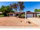 Charming single-story home featuring a well-maintained front yard with mature trees and a two-car garage at 8238 E Jackrabbit Rd, Scottsdale, AZ 85250