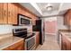 Modern kitchen featuring stainless steel appliances and warm wood cabinets at 8238 E Jackrabbit Rd, Scottsdale, AZ 85250