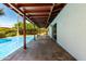 A covered patio with exposed beams overlooks a sparkling pool and a well maintained yard at 8238 E Jackrabbit Rd, Scottsdale, AZ 85250