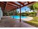 View of a backyard pool with covered patio and lush landscaping, perfect for entertaining at 8238 E Jackrabbit Rd, Scottsdale, AZ 85250