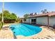 A sparkling blue pool is surrounded by a brick patio and mature landscaping at 8238 E Jackrabbit Rd, Scottsdale, AZ 85250