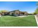Wide view of the backyard, lawn, and covered patio at 8240 E Wingspan Way, Scottsdale, AZ 85255
