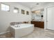 Luxurious bathroom features a soaking tub, mosaic tile accents, and a vanity with double sinks at 8240 E Wingspan Way, Scottsdale, AZ 85255