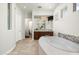 Well-lit bathroom showcasing a soaking tub with mosaic accents, dual sink vanity, and neutral tile flooring at 8240 E Wingspan Way, Scottsdale, AZ 85255