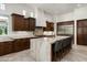 Elegant kitchen with dark cabinets, an oversized island, and stainless steel appliances at 8240 E Wingspan Way, Scottsdale, AZ 85255