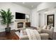 Inviting living room with a cozy fireplace, hardwood floors, and comfortable seating arrangement at 8240 E Wingspan Way, Scottsdale, AZ 85255