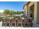 Outdoor dining area on patio with grill and bar area next to a manicured lawn at 8240 E Wingspan Way, Scottsdale, AZ 85255