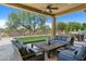 Relaxing covered patio with comfortable seating, outdoor dining, and manicured backyard at 8240 E Wingspan Way, Scottsdale, AZ 85255