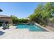 Inviting backyard pool with water feature, paved patio, and lush landscaping for outdoor enjoyment at 8240 E Wingspan Way, Scottsdale, AZ 85255