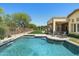 A refreshing backyard pool featuring a tranquil waterfall feature, manicured lawn and outdoor patio seating at 8240 E Wingspan Way, Scottsdale, AZ 85255