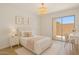 Bright bedroom featuring a cozy bed, a light fixture, and a sliding door to the outside at 8414 N Central Ave # B, Phoenix, AZ 85020