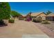 Lovely single-story tan home with three-car garage and colorful desert landscaping at 8627 W Morrow Dr, Peoria, AZ 85382
