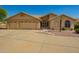 Charming tan home featuring a three-car garage and desert landscaping at 8627 W Morrow Dr, Peoria, AZ 85382