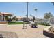 Open backyard showing a built-in fire pit, with outdoor seating areas, artificial turf, and mature trees at 920 N 104Th St, Mesa, AZ 85207