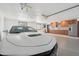 Garage with epoxy flooring featuring stainless steel refrigerator and cabinets with an adjacent sports car at 920 N 104Th St, Mesa, AZ 85207