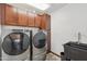 Updated laundry room features front load washer and dryer with dark brown cabinets and utility sink at 920 N 104Th St, Mesa, AZ 85207