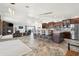 Open-concept living space with a stone fireplace, kitchen with bar seating and stainless steel appliances at 920 N 104Th St, Mesa, AZ 85207