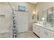 Well-lit bathroom with dual sinks, white cabinets, and a walk-in shower with a glass door at 9484 N 105Th Pl, Scottsdale, AZ 85258