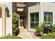 Inviting front porch with mature plants and a decorative screen door at 9484 N 105Th Pl, Scottsdale, AZ 85258