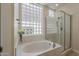 Bright bathroom featuring a soaking tub, a glass-enclosed shower, and lots of natural light at 9562 E Cavalry Dr, Scottsdale, AZ 85262