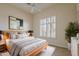 Bright bedroom featuring a large window with shutters, a soft rug, and a comfortable platform bed at 9562 E Cavalry Dr, Scottsdale, AZ 85262
