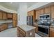 Bright kitchen featuring wood cabinetry, granite countertops, a center island, and stainless steel appliances at 9562 E Cavalry Dr, Scottsdale, AZ 85262