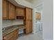 Laundry room with wooden cabinets, granite countertop, and modern washer and dryer at 9562 E Cavalry Dr, Scottsdale, AZ 85262