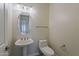 Powder room with pedestal sink, oval mirror and neutral walls at 9562 E Cavalry Dr, Scottsdale, AZ 85262