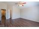 Bedroom with wood-look floors, ceiling fan, and easy access to the hallway and closet at 10649 W Alvarado Rd, Avondale, AZ 85392