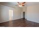 Bright bedroom boasts wood-look floors, a ceiling fan, and convenient access to the bathroom at 10649 W Alvarado Rd, Avondale, AZ 85392