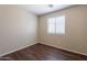 Bright bedroom featuring wood-look floors and a window providing natural light at 10649 W Alvarado Rd, Avondale, AZ 85392