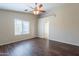 Spacious bedroom featuring wood-look floors, a modern ceiling fan, and lots of natural light at 10649 W Alvarado Rd, Avondale, AZ 85392