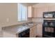 Well-lit kitchen features modern appliances, laminate countertops, and a stainless steel dual basin sink at 10649 W Alvarado Rd, Avondale, AZ 85392