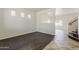 A bright, empty living room with wood floors and staircase access at 11016 W Griswold Rd, Peoria, AZ 85345