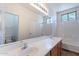 Bright bathroom featuring double sinks, tiled shower over tub, and a neutral color palette at 1244 S Tacoma --, Mesa, AZ 85209