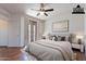 This main bedroom boasts a ceiling fan, private balcony access, and is virtually staged with warm furniture at 1244 S Tacoma --, Mesa, AZ 85209