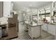 Bright kitchen featuring white cabinetry, stainless steel appliances, and dark countertops with an island at 13631 N 70Th Dr, Peoria, AZ 85381