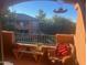 Balcony with a view of green trees, an apartment building, seating, and a small table at 14950 W Mountain View Blvd # 5303, Surprise, AZ 85374