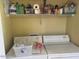 Laundry room with a white washer and dryer, and a shelf with various cleaning supplies at 14950 W Mountain View Blvd # 5303, Surprise, AZ 85374