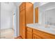 Bathroom with single vanity, warm wood cabinet, tile floor, and archway to bedroom at 16620 S 48Th St # 79, Phoenix, AZ 85048