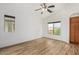 Spacious bedroom with wood flooring, ceiling fan, and abundant natural light from two windows at 16620 S 48Th St # 79, Phoenix, AZ 85048