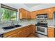 Well-lit kitchen featuring wooden cabinets, stainless steel appliances, and a stylish tile backsplash at 16620 S 48Th St # 79, Phoenix, AZ 85048