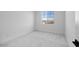 Bright bedroom features neutral carpet, white walls and trim, and natural light from a window at 16810 W Yucatan Dr, Surprise, AZ 85388