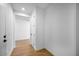 Bright hallway with wood-look flooring and white walls leading to additional rooms at 16810 W Yucatan Dr, Surprise, AZ 85388